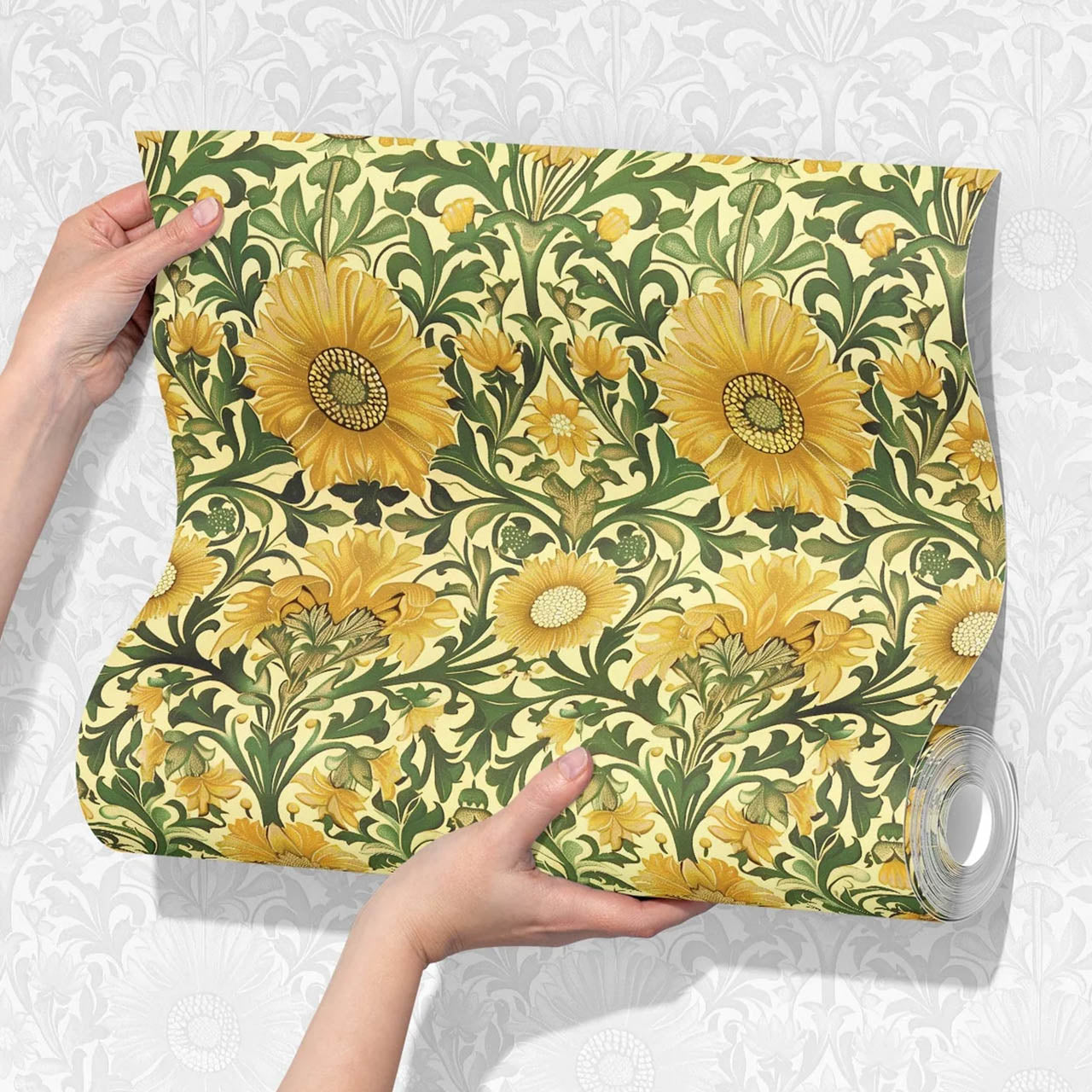 Händer som håller upp en tapet med klassiskt blomstermönster i gult och grönt – inspirerat av historiska mönster.