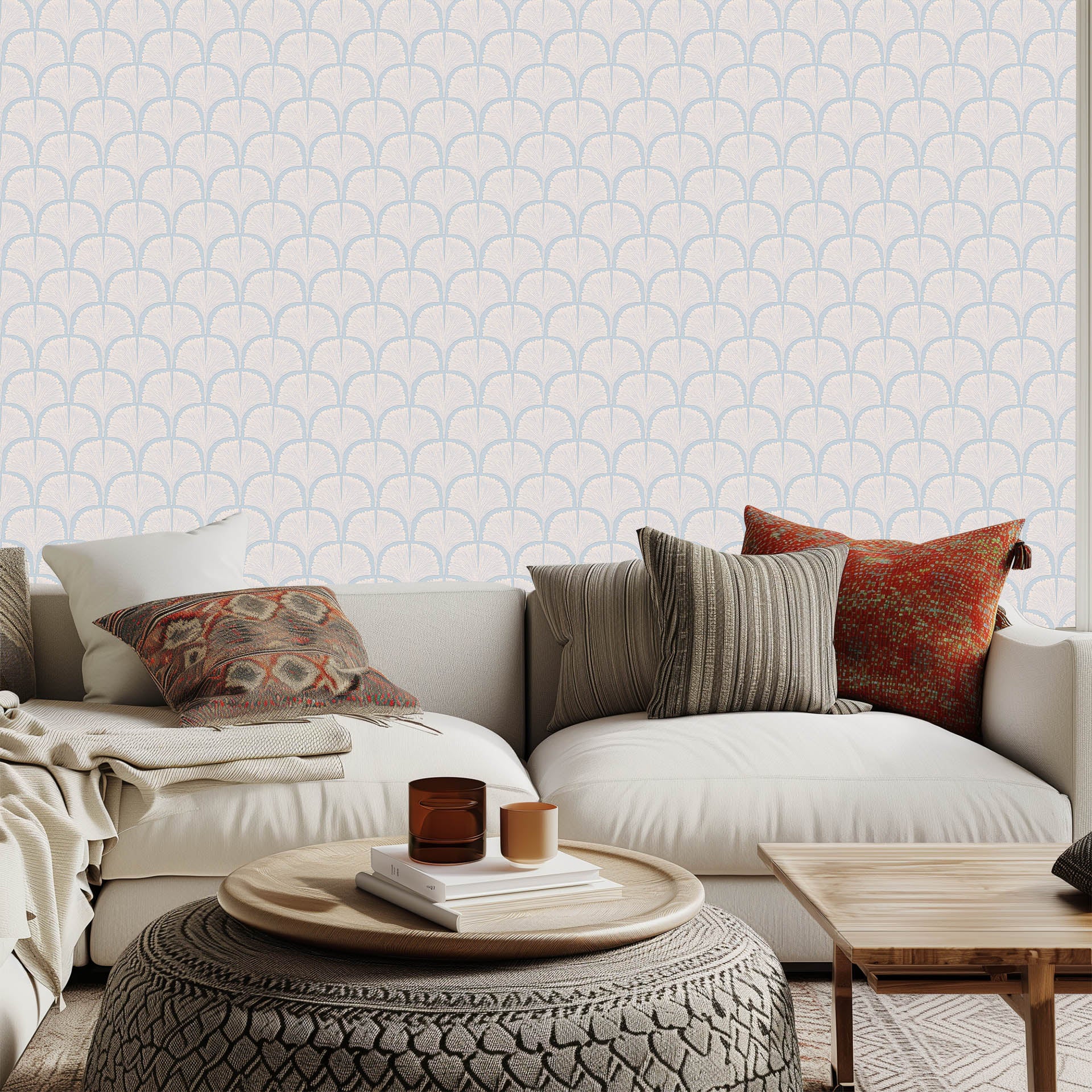 Vardagsrum med ljus geometrisk tapet i beige – ombonat med soffa, kuddar och runt soffbord.