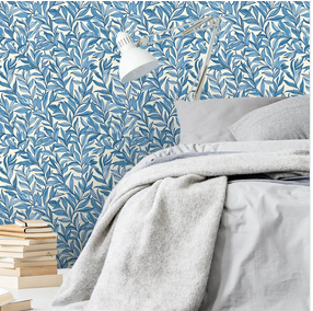Sovrum med blå lövtapet i tätt mönster – lugn och naturlig känsla med sängkläder i grått. 
